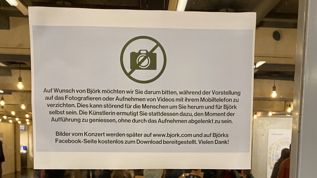 Schild: Auf Wunsch von Björk möchten wir Sie darum bitten, während der Vorstellung auf das Fotografieren oder Aufnehmen mit ihrem Mobiltelefon zu verzichten.
